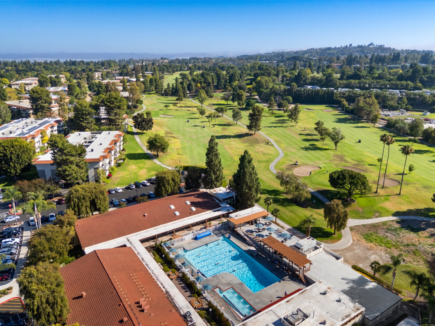 Aerial view of pool complex with golf course backdrop