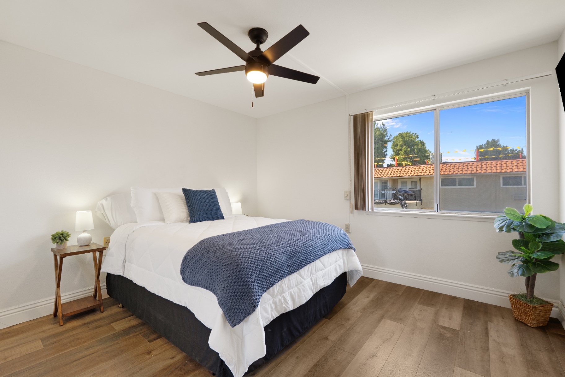 Primary bedroom with queen bed, ceiling fan, and neighborhood window